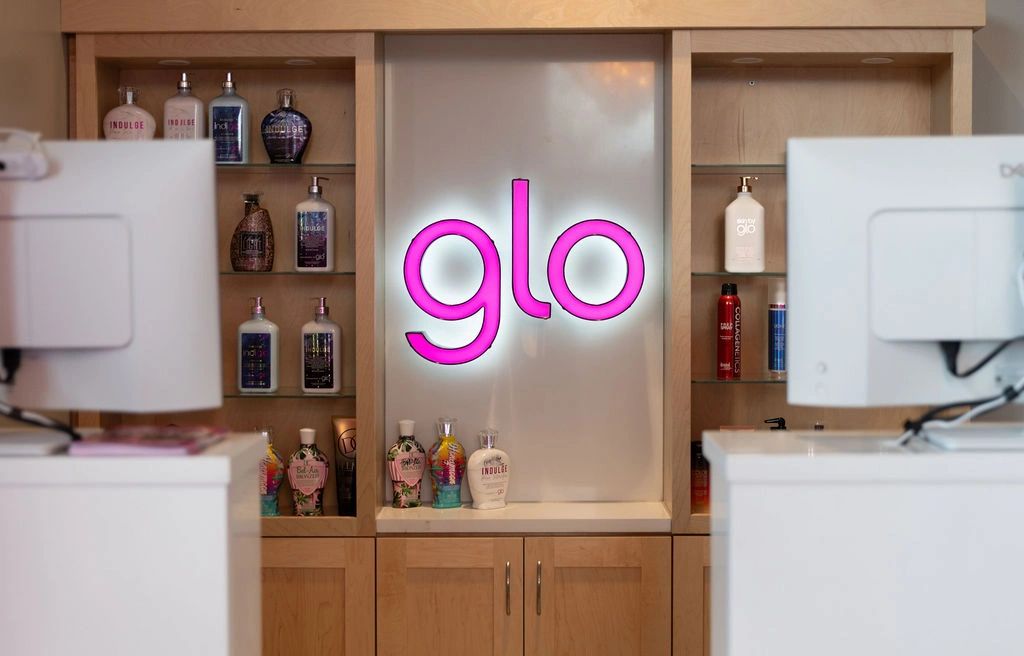 GloTanning shows off their branded sign in their Zephyrhills, Florida branding photosession.
