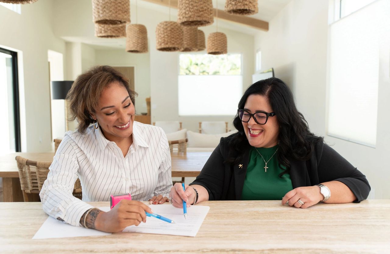 Mobile notary Donish Miller and Realtor Elena Ivani work on a contract in St. Pete, Florida